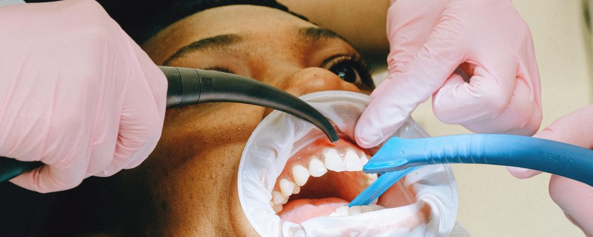 Close-up of a dental professional performing a checkup on a patient in a clinic setting.
